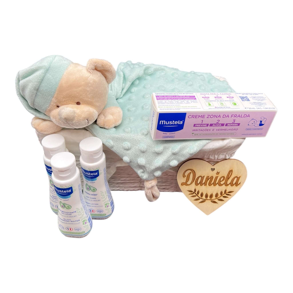 Primera canastilla para nacimientos con cositas para el bebé: pañales, productos de higiene y osito doudou atrapa sueños.