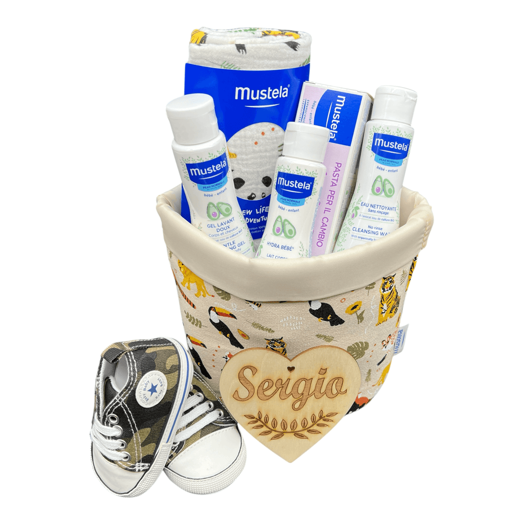 Cestita con pañales Dodot y productos Mustela para la higiene y el cuidado del bebé y con zapatitos primeros pasitos.